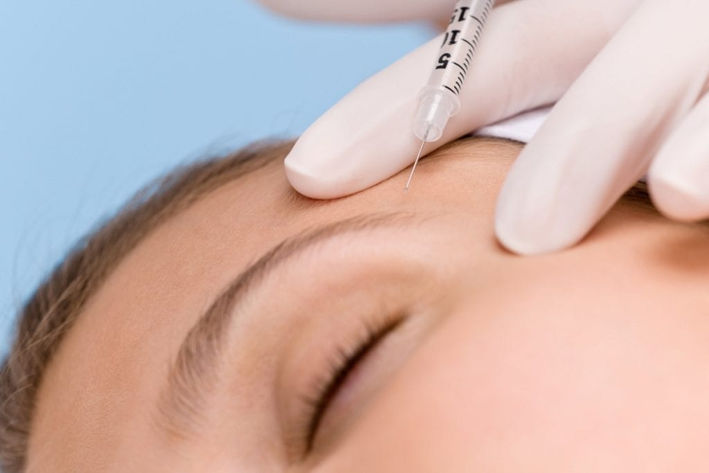 Botox injection - woman in cosmetic medicine treatment